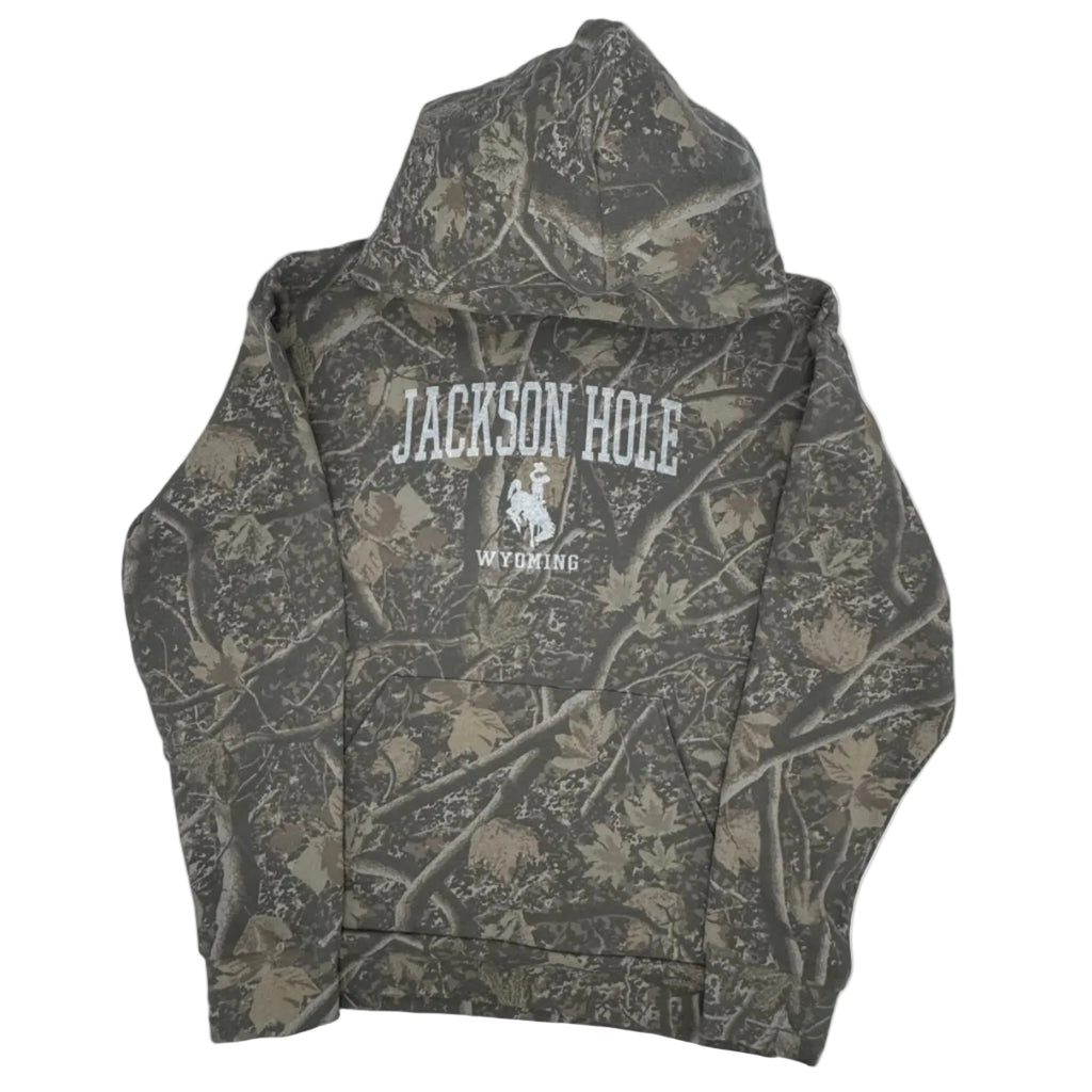 Camouflage-patterned hoodie with branding inside a gray bag on a white background